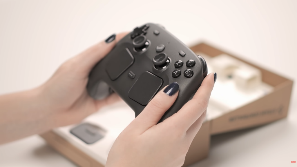Steam Controller wird gehalten vor seiner Verpackung
